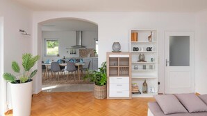 A modern living room with a wooden herringbone floor, a grey sofa, and a white door. - Awesome home in Vinjani Donji (Vinjani Donji)