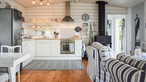 A compact kitchen with white cabinets, a stove, and a clock on the wall. - Amazing home in Ronneby with house sea view (Ronneby)