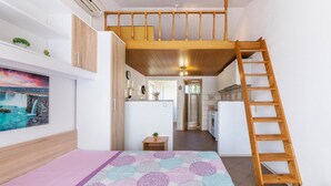 Een compacte leefruimte met een slaapverblijf op entresol, een keuken en een badkamer.