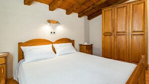 A wooden bed with a headboard, two bedside tables, and a wardrobe. - 2 bedroom cozy home in Zminj (Zminj)