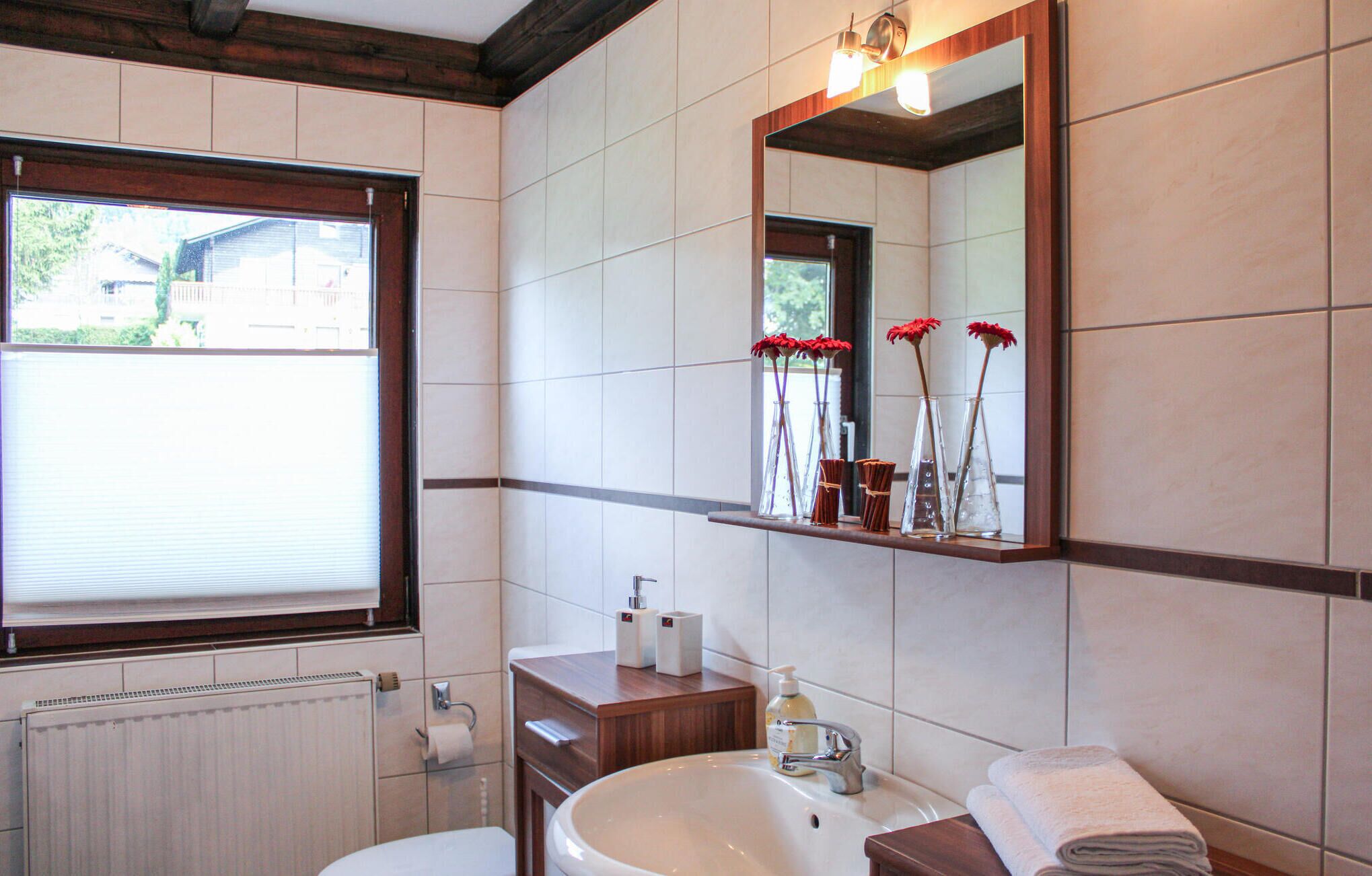 A bathroom with a large sink, a mirror, and a window.