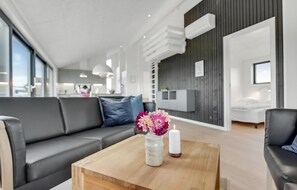 Relax in this stylish living room with a grey leather sofa, wooden coffee table, and large window.
