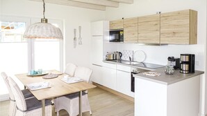 A modern kitchen with white cabinets, a built-in oven, and a coffee maker. - Stunning home in Büsum with sauna (Büsum)