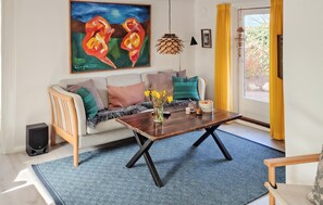 Un salon avec un canapé, une table basse et un tableau.