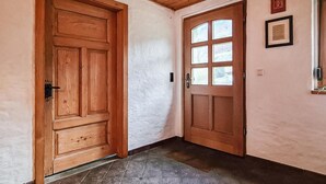 A hallway with wooden doors and a tiled floor. - Ferienhaus Lausche Haeusl (Waltersdorf)