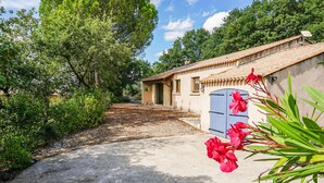 A rustic house with a tiled roof, a blue door, and a gravel driveway. - Beautiful home in Caux (Caux)