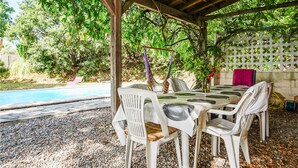 An outdoor patio with a pool, surrounded by trees and a pergola. - Beautiful home in Caux (Caux)