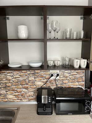 Micro-ondes, cafetière/bouilloire, moulin à café, tables à manger