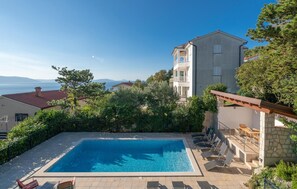 Una piscina al aire libre, tumbonas