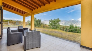 Un patio exterior con mobiliario de mimbre y vistas a montañas.
