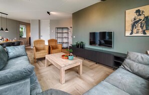 Relax in this stylish living room with a sofa, coffee table, and mounted TV.