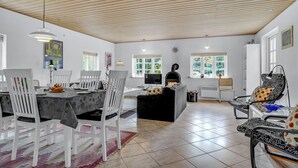 A spacious living area with a fireplace, dining table, and comfortable seating. - 3 bedroom nice home in Læsø (Læsø)