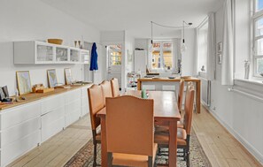 Enjoy meals in the kitchen and dining area with a wooden table and comfortable seating.