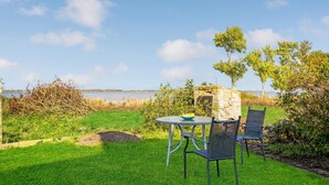 A garden with a stone wall, a round table, and two chairs. - 4 bedroom stunning home in Torrig L (Torrig L)