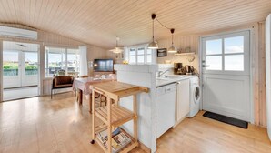 Une cuisine spacieuse avec un coin repas, un lave-linge et un téléviseur.