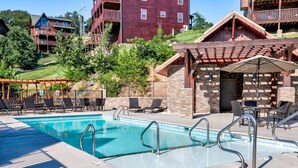 Un espace piscine avec des chaises longues et un bâtiment en pierre.