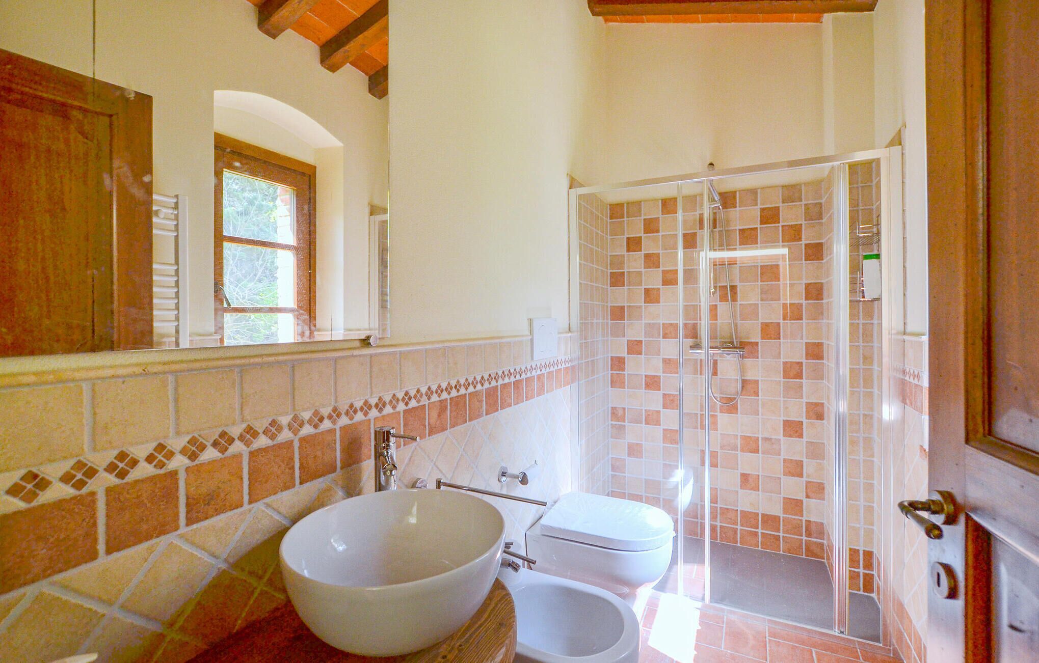 Une salle de bain avec un grand lavabo blanc, des toilettes et une douche à parois de verre.