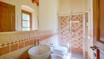 Une salle de bain avec un grand lavabo blanc, des toilettes et une douche à parois de verre.