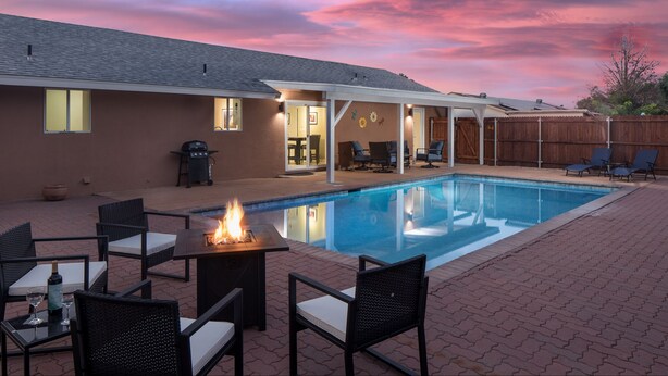 A backyard with a swimming pool, patio furniture, and a fire pit. - Pool, Hot tub, Fire Pit, BBQ ~  Beautiful home with patio living at it's best! (Cottonwood)