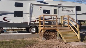 Un camping-car Durango doté d’un escalier en bois menant à une zone abritée.