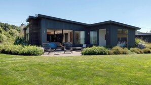 Een modern huis met twee verdiepingen en een overdekt terras.