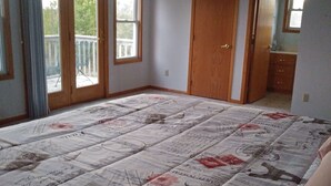A bedroom with a large bed, a wooden door, and a balcony. - Quiet, remotely located in the country. (Eden Valley)