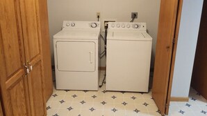 A laundry room with two white washing machines and a wooden door. - Quiet, remotely located in the country. (Eden Valley)