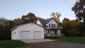 A two-story house with a garage, a balcony, and a driveway. - Quiet, remotely located in the country. (Eden Valley)