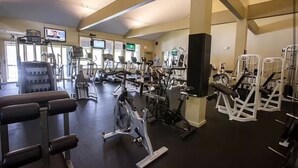 A gym with various exercise machines, including treadmills, elliptical trainers, and weight machines.