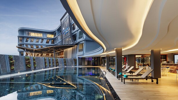A modern hotel with a large indoor pool, lounge areas, and a distinctive architectural design. - The Oceanic Sportel Phuket - SHA Extra Plus (Ko Kaeo)