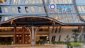 A modern hotel entrance with a distinctive curved roof and a prominent sign reading "The OCEANIC SPA HOTEL". - The Oceanic Sportel Phuket - SHA Extra Plus (Ko Kaeo)