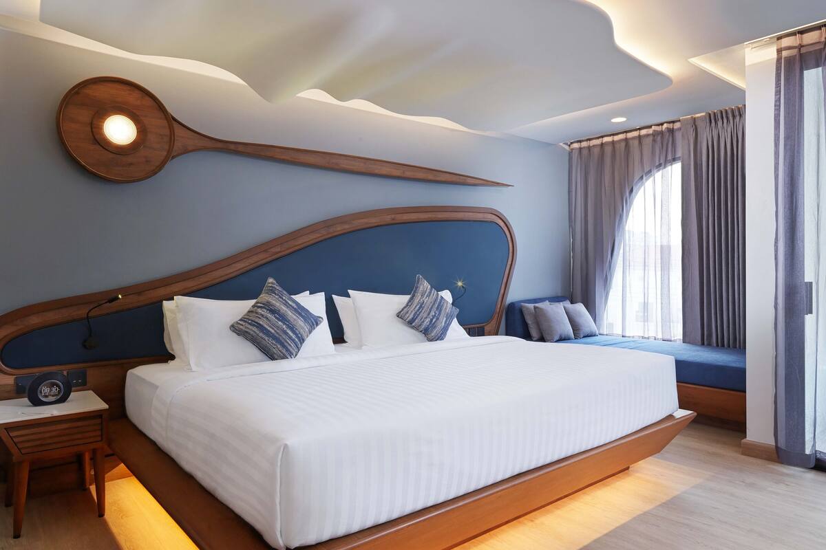 A modern bedroom with a large bed, wooden headboard, and a unique ceiling design.