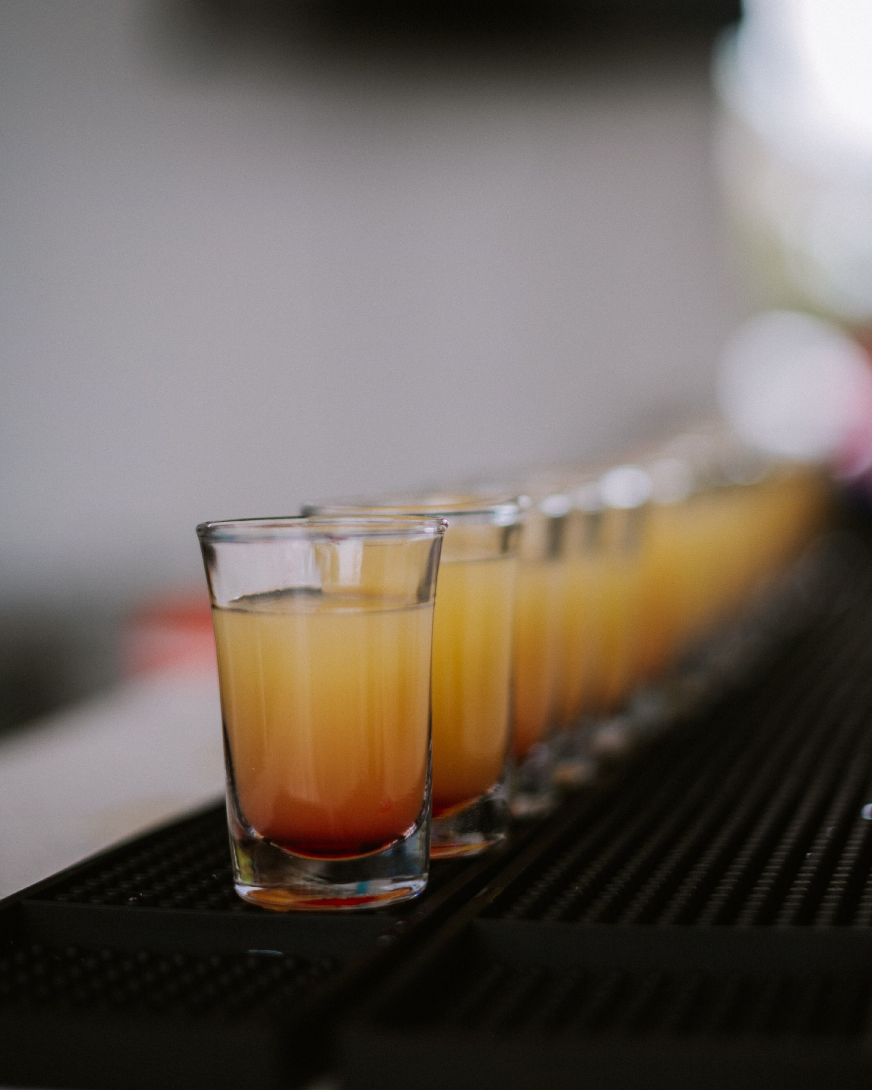 Une rangée de verres à shooter sur un plateau.