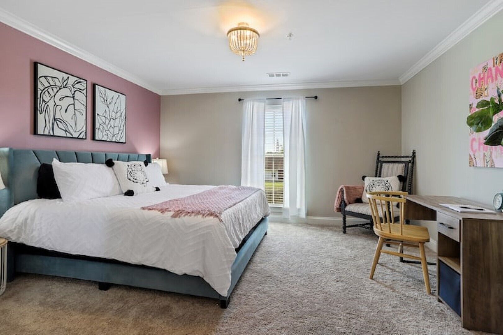 A bedroom with a bed, a desk, and a chair.