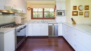 A kitchen with white cabinets, a stainless steel stove, a microwave, and a dishwasher. - Moffat Falls Lodge (Ebor)