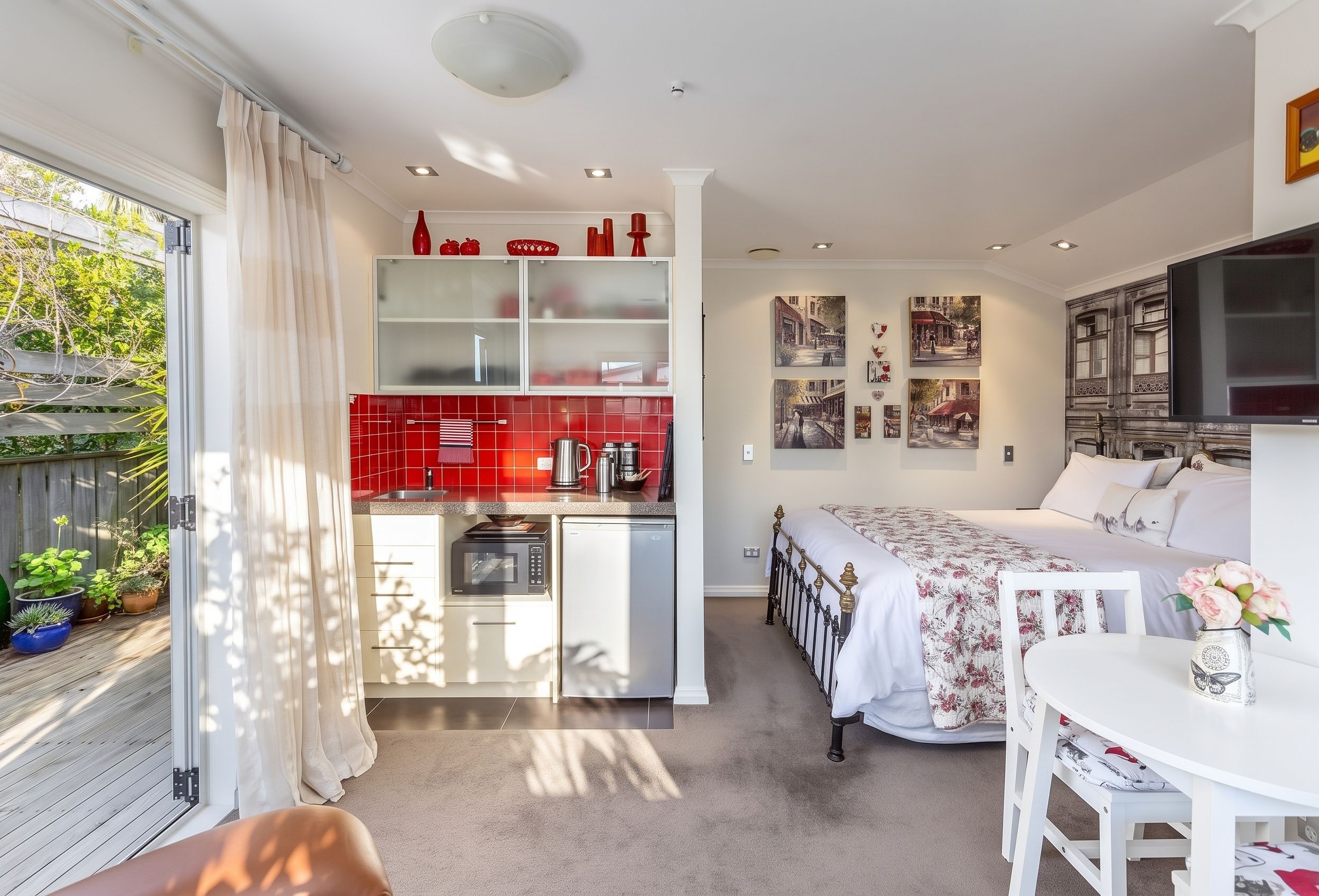 Un studio compact comprenant un coin cuisine, un espace repas et une chambre.
