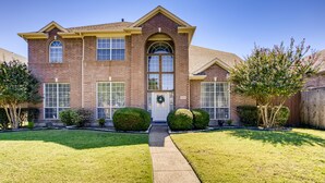 A two-story brick house with a front entrance, a mailbox, and a well-maintained lawn. - Big 5 Bed/ 3.5 Bath Modern Home ⌂ Disney+ included, Free Parking, Fast Wi-Fi (Plano)