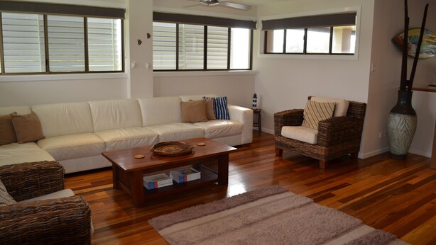 A living room with a sofa, a chair, a coffee table, and a large vase. - 'SEASIDE RETREAT' beach & nature at your doorstep (Wooli)