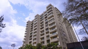 Un edifici alt amb múltiples balcons i un cel serè.
