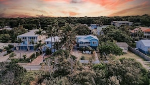 Zona residencial con casas, palmeras y un cielo al atardecer.