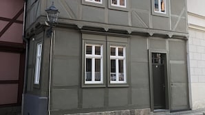 A two-story building with a dark facade, multiple windows, and a tiled roof. - Harz cosiness (Quedlinburg)