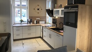 A modern kitchen with white cabinets, a built-in microwave, and a Siemens oven. - Harz cosiness (Quedlinburg)