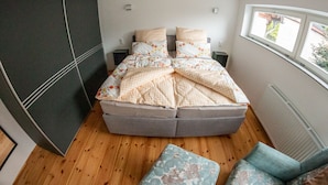 A bedroom with a bed, two nightstands, a window, and a radiator. - Harz cosiness (Quedlinburg)