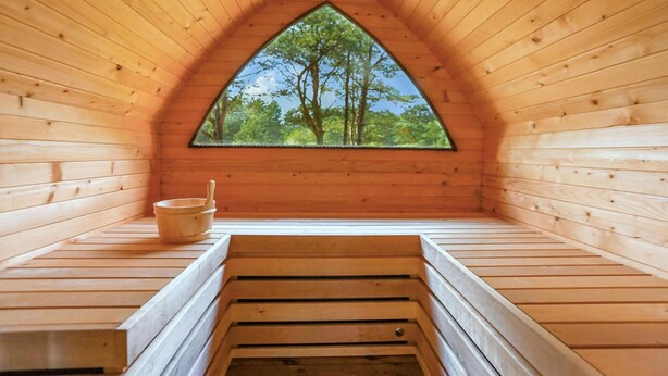 A wooden attic room with a triangular window, a wooden bench, and a wooden bucket. - Gorgeous home in Pasym with sauna (Pasym)