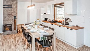 A modern kitchen with white cabinets, a wooden countertop, and a built-in oven. - Gorgeous home in Pasym with sauna (Pasym)