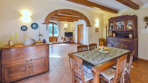 Una cocina rústica con armarios de madera, una mesa de comedor con sillas y una chimenea de ladrillo.
