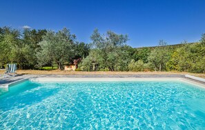 Relax by the serene pool surrounded by lush greenery and a tranquil atmosphere.
