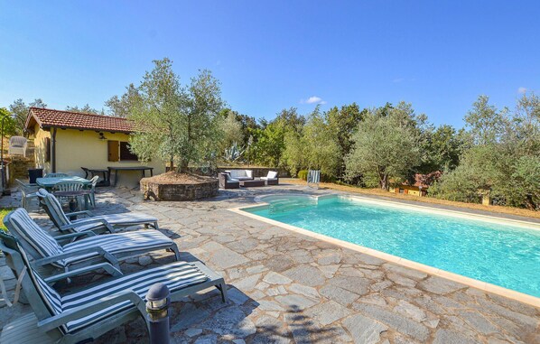 Relax by the serene pool surrounded by lush greenery and trees.