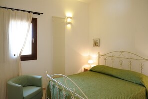 A bedroom with a bed, a chair, a nightstand, and a wall-mounted lamp. - New Panoramic Casa degli Ulivi, Private Pool, private terrace WIFi (Martina Franca)