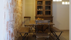 Un coin repas avec un mur en briques, un meuble en bois et une étagère en métal.